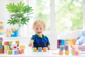 Child learning letters. Kid with wooden abc blocks - 789938674
