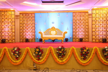 Indian style stage decoration with blue backdrop decorated with lotus flowers and bells