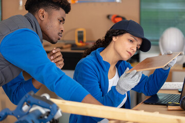young male and female workers examining materials