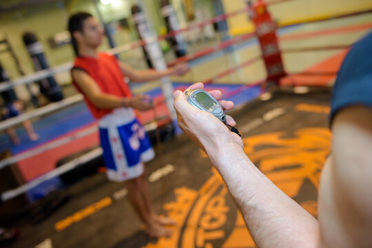 Personal trainer holding stop watch - Powered by Adobe