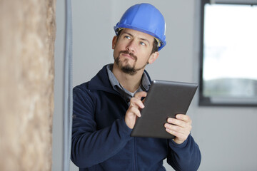 builder with a tablet for papers