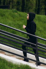 Fototapeta premium Young exercise woman running alone up stairs
