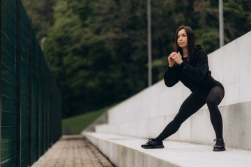 Athletic woman doing reverse push up on stairs outdoor fitness. - obrazy, fototapety, plakaty
