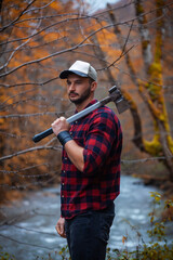 Portrait of Handsome Young Man with Axe and Checkered Shirt in Foggy Autumn Forest - 789964683