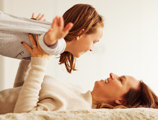 Mom, girl and happy with plane on bed with smile, care and bonding with games in morning at family...