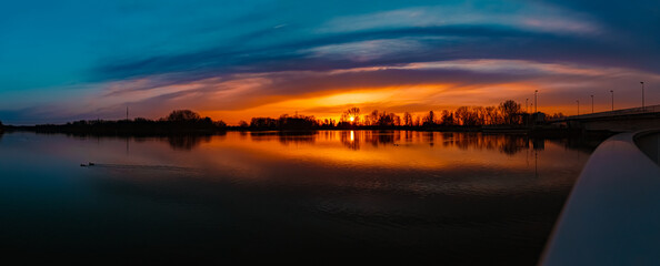 High resolution stitched spring sunset panorama with reflections near Plattling, Isar, Bavaria,...