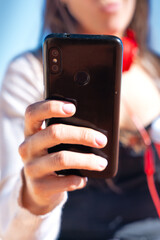 Vertical portrait Unrecognizable young woman using smartphone app outdoors.