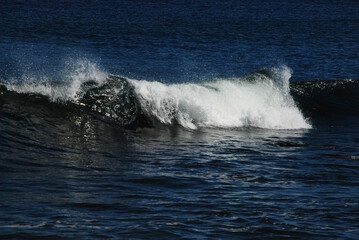 waves at the sea shore, rollingon blue ocean water, white cap