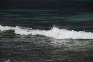 Fototapeta premium waves at the sea shore, rollingon blue ocean water, white cap