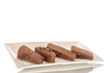 A few pieces of chocolate waffle cake on a white ceramic plate macro, isolated on a white background.