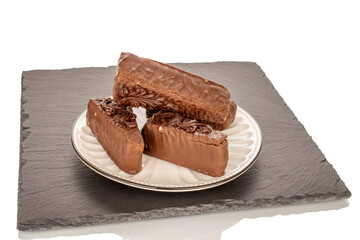 Three pieces of chocolate waffle cake with white ceramic saucer on slate stone, macro, isolated on white background.