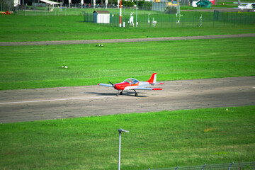 small red airplane on the runway