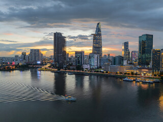 Fototapeta premium Aerial drone skyline video of Saigon cityscape at sunset in District 1, with Sai Gon river view