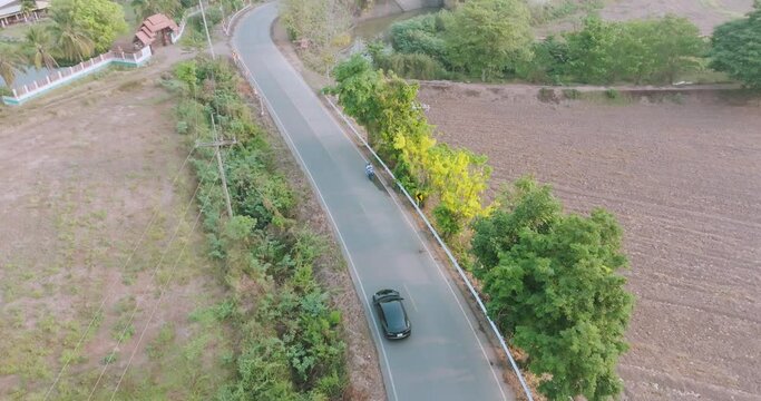 Aerial view electric vehicle EV car on green forest asphalt road, Concept of using electric cars to protect the environment and transportation.