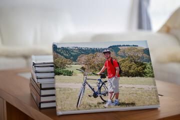 Photobook of family holiday trips with piles of photo albums on the coffee table. - 789985472