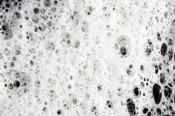 Soap bubbles texture. Black teflon frying pan cleaning. White suds pattern. Liquid detergent foam. Closeup shampoo bubbles. Washing dishes background. White foam on lake surface closeup structure.