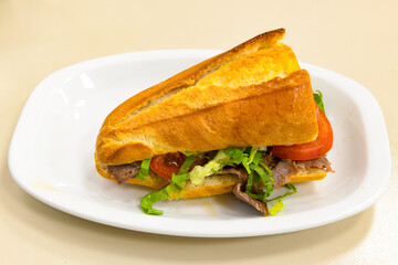 Turkish and Arabic Traditional Ramadan doner kebab with tasty tomato sauce and rice or turkish pilav in white plate on wood table background. ( Pilav ustu doner). Ekmek arasi doner, doner durum. 