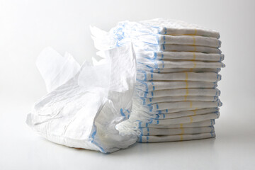 Pile of diapers on white table isolated on bench background