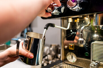 Barista skillfully steaming milk for a fresh cup of coffee, capturing the intricate details of coffee preparation