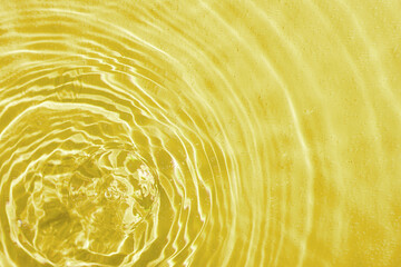 drops on water with circles on a yellow background
