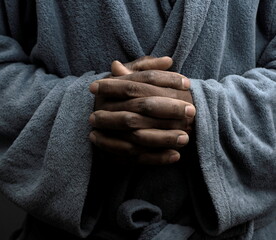 praying to god with hands together Caribbean man praying on black background with people stock...