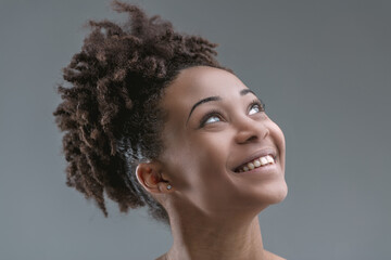 Afro-haired woman, exuberant, anticipates with smile