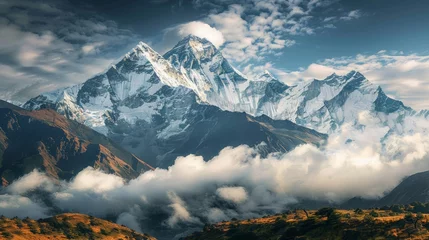 Fotobehang A serene landscape with snow-capped mountains rising majestically into the clouds, their rugged beauty capturing the essence of nature's splendor. © chanidapa