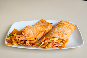 Turkish and Arabic Traditional Ramadan doner kebab with tasty tomato sauce and rice or turkish pilav in white plate on wood table background. ( Pilav ustu doner). Ekmek arasi doner, doner durum. 
