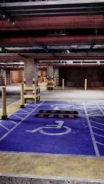 An underground parking garage devoid of cars, featuring a wheelchair ramp for accessibility.