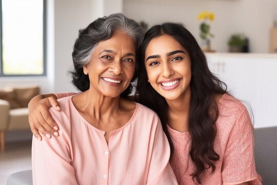 Happy indian elderly mom and young daughter hugging together