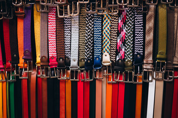 Display of colorful handmade leather belts. Many leather belts on the market
