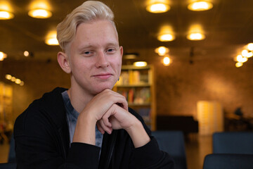 A student smiles at the camera in a modern library