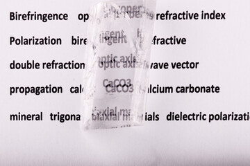 Optical birefringence demonstrated using a text using a natural double spar calcite crystal