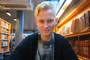 A young blond student studies in the university library