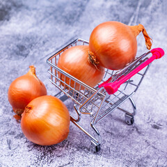 Fresh onions in shopping cart