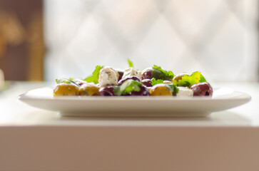 Fresh Greek salad based on green and black olives with pieces of white feta cheese and parsley