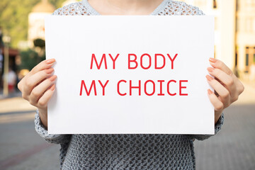 Woman holding poster my body is my choice, demanding autonomy over reproductive decisions,...