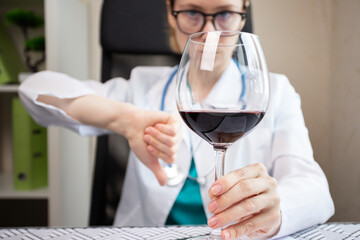 Doctor prohibits alcohol, shows thumbs down to glass of wine, medical care, patient treatment,...