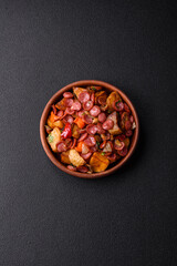 Grilled potatoes cut into slices with hunting sausages with garlic, onion