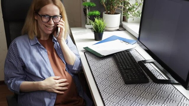 Office pregnancy, expecting employee engaged in her job tasks and computer work