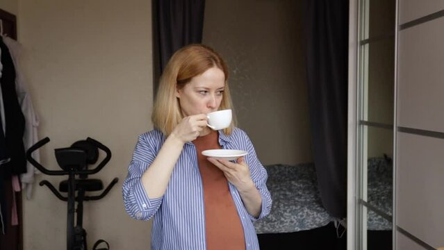 Pregnant woman drinking coffee, sipping her cup, mindful pregnancy, embracing changes