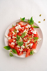 Salad of watermelon and soft cheese with mint, light background, no people, top view