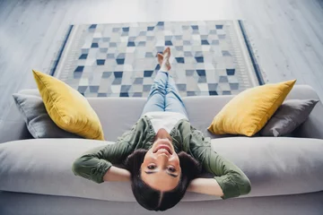 Fotobehang Full size high angle view photo of pretty young lady sit couch wear green shirt weekend modern apartment indoors © deagreez