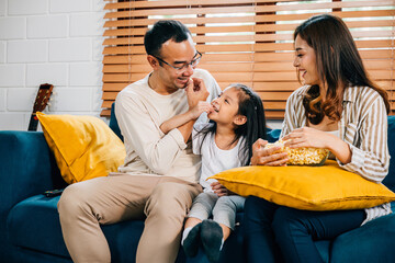 A modern family sits on grooved sofa enjoying togetherness while watching TV with popcorn. father mother daughter and sibling share laughter smiles and moments of joy during their quality family time.