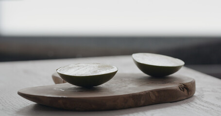 ripe mango halves on olive wood board