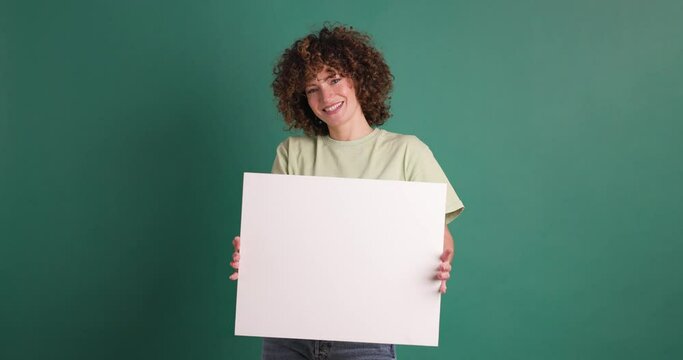 Happy woman holding blank paper in green background