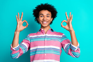 Photo of positive funny man wear stylish clothes showing gesture okey sign isolated on cyan color...
