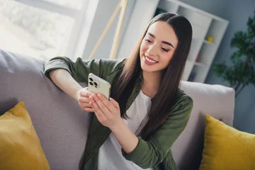 Gartenposter Photo of pretty young woman texting smart phone wear shirt modern interior apartment indoors © deagreez