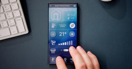 Hand Using Mobile Phone With Home Control System