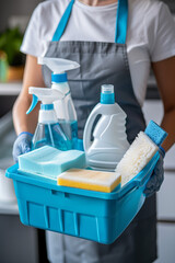 A woman cleaner in an apron and gloves with a bucket of cleaning products. Housecleaning with detergents, cleaning supplies.